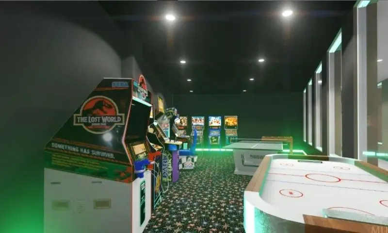 A room with several arcade machines and green lights.