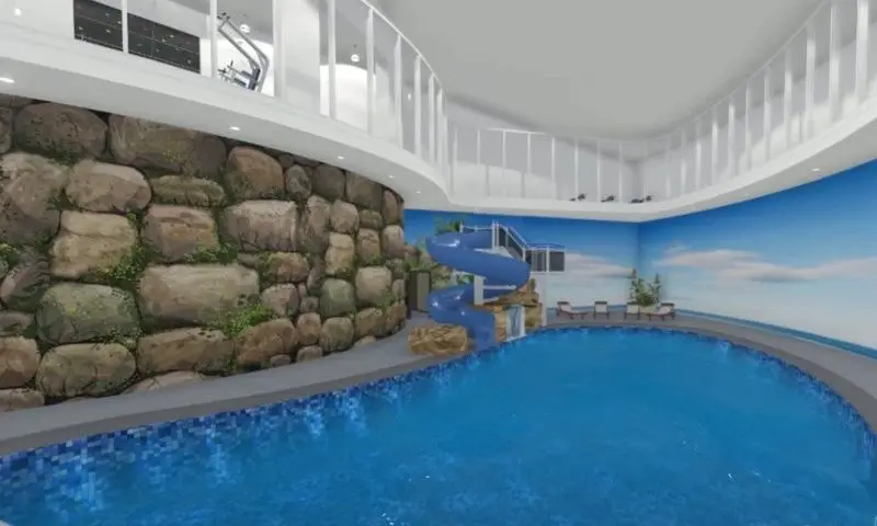 A swimming pool with a slide and rock wall