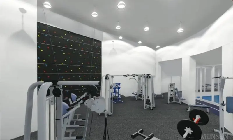 A gym with many machines and lights on the wall