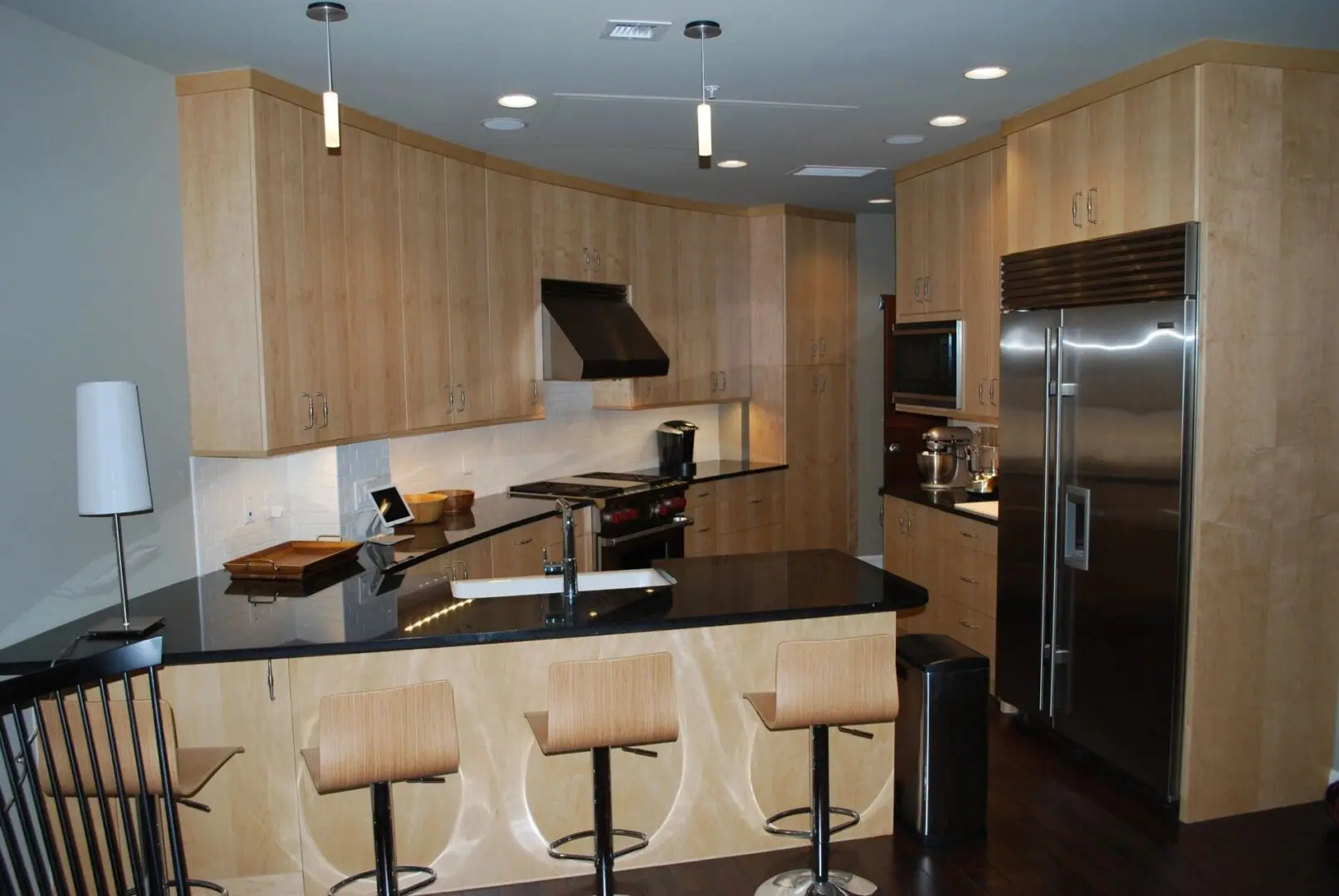 A kitchen with wooden cabinets and black counter tops.