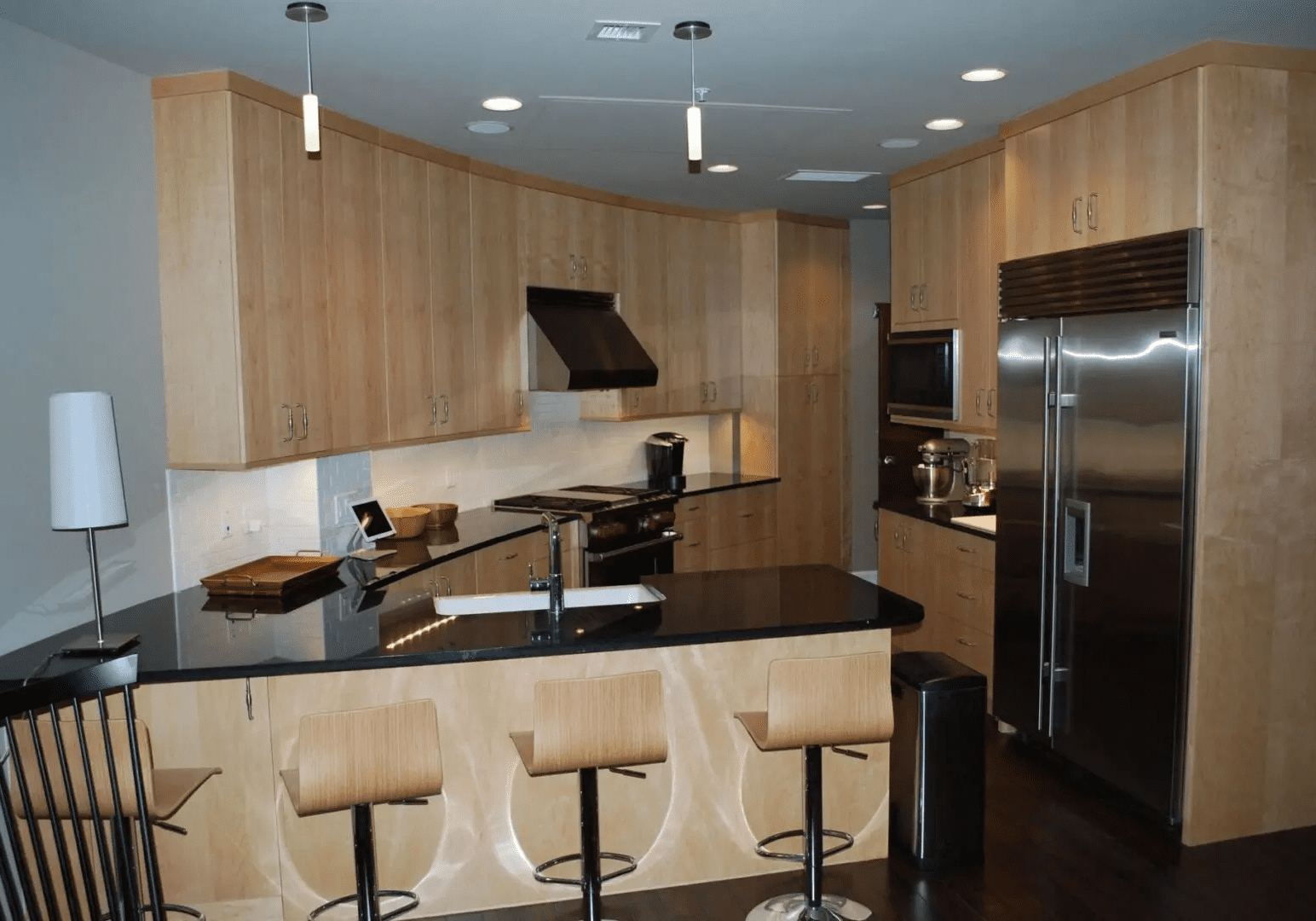 A kitchen with wooden cabinets and black counter tops.